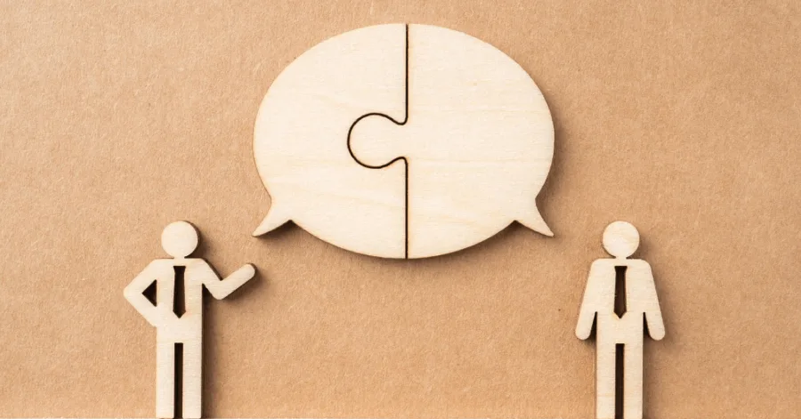 Two wooden shaped cut outs having a conversation