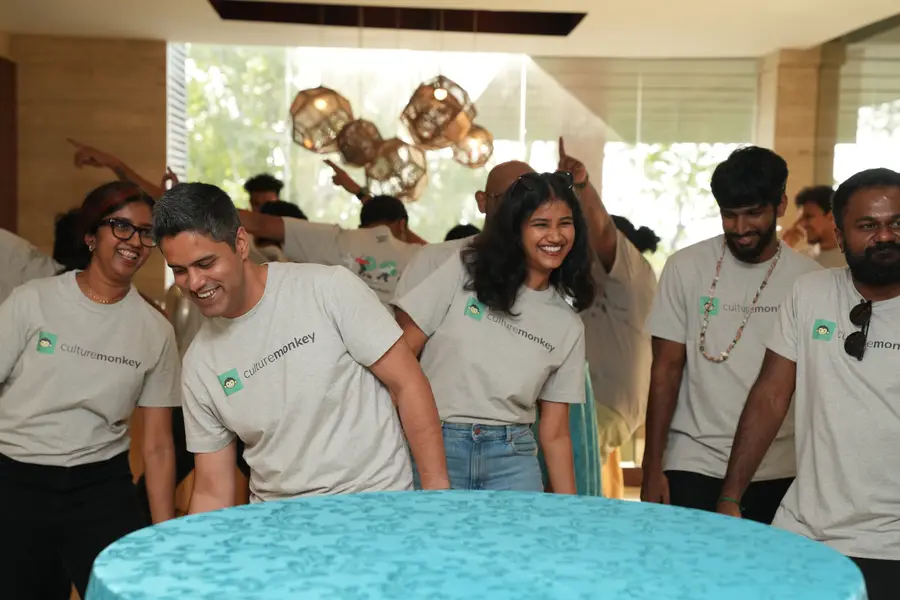 The team laughing around a table during a retreat game